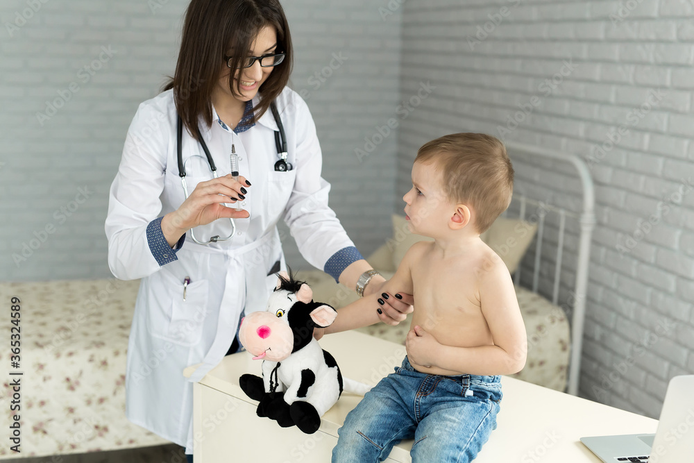 Doctor pediatrician giving child an intramuscular injection in arm Doctor pediatrician giving child an intramuscular injection in arm