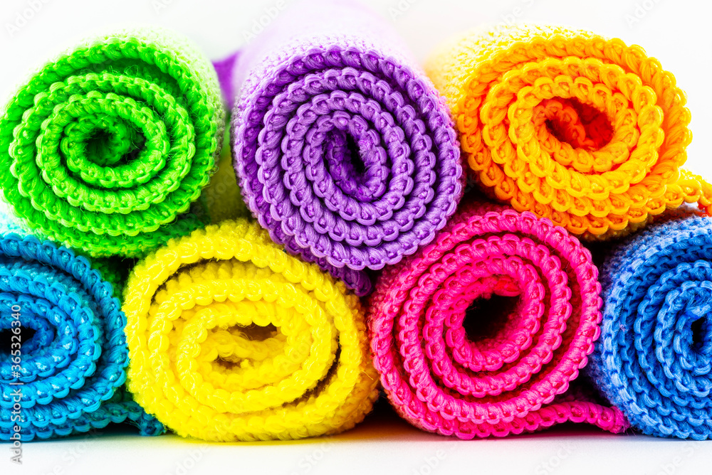 Background made of different colors of microfiber material, rolled up and stacked on top of each other, front view, macro shot. Background made of different colors of microfiber material, rolled up and stacked on top of each other, front view, macro shot.
