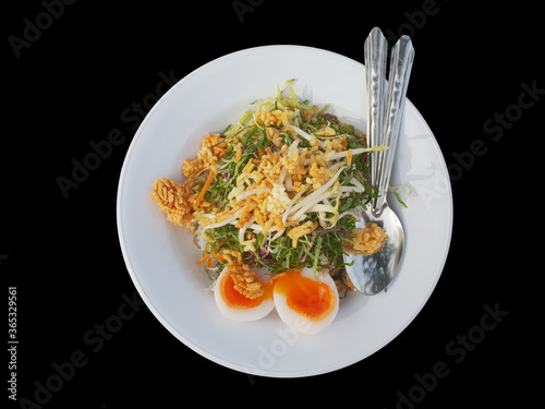 Khao Yum Rice with mixed herb vegetables Thai local southern style dish alongwith boiled eggs ready to eat isolated on black background
 photo