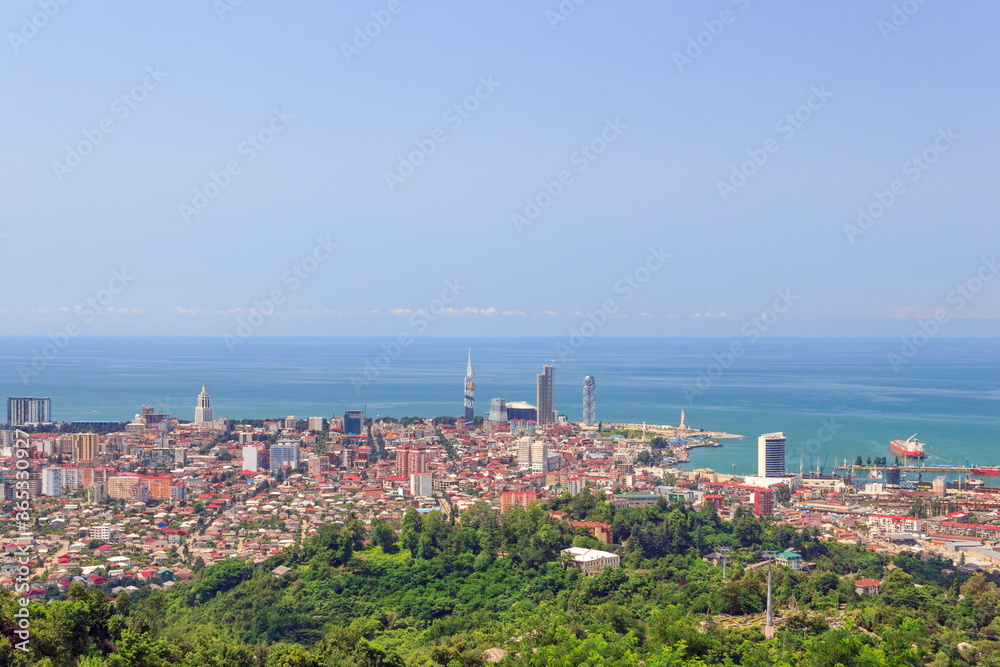 Summer landscape. In the foreground is green vegetation. Top view of the Black Sea and the city of Batumi, the capital of Adjara. Place for text, design postcard, calendar or poster. Georgia, Eurasia.