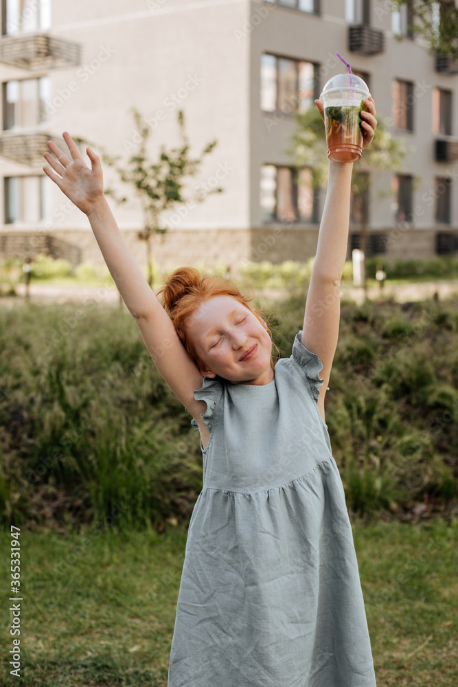 Obraz premium Red-haired girl enjoying a summer day