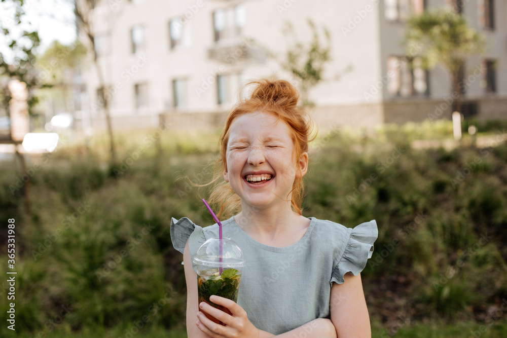 Red-haired girl laughing on a sunny summer day Red-haired girl laughing on a sunny summer day
