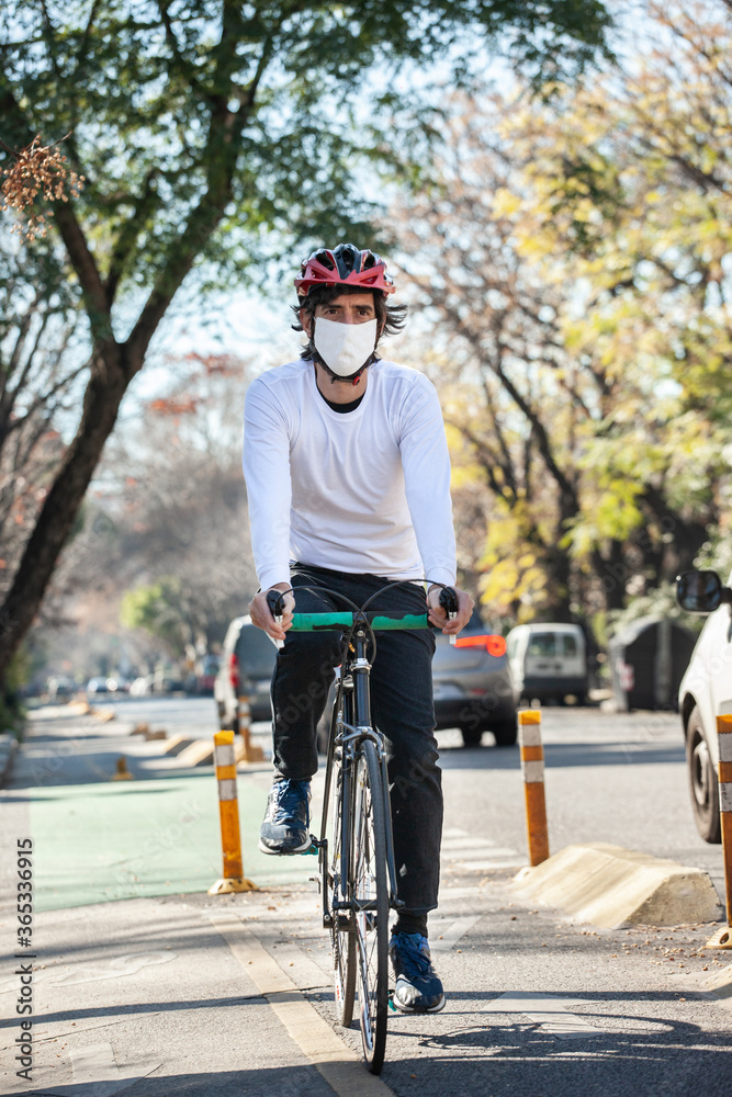 Cyclist riding a bicycle with face mask on a sunny day