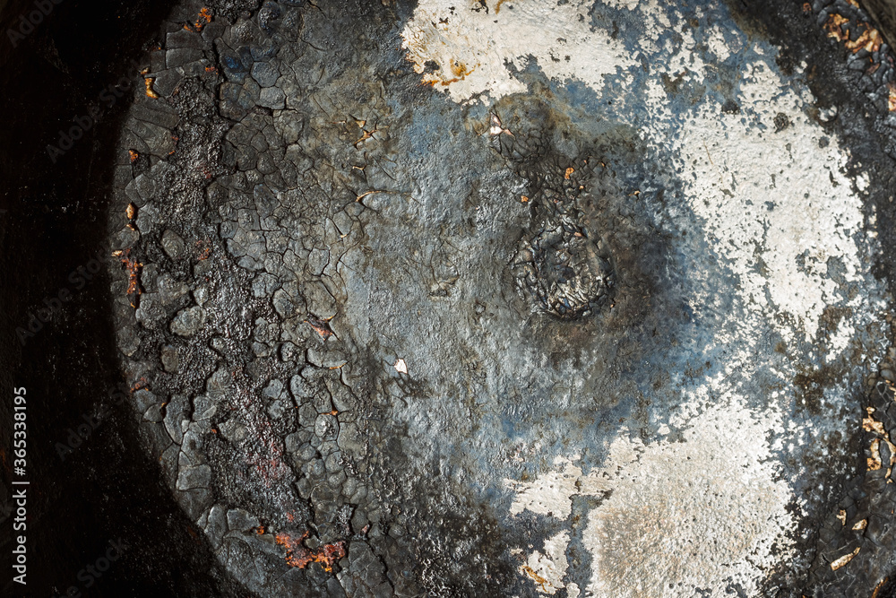Naklejka premium The texture of the burnt bottom of the cast iron pan