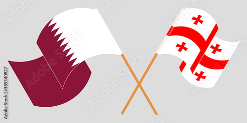 Crossed and waving flags of Georgia and Qatar