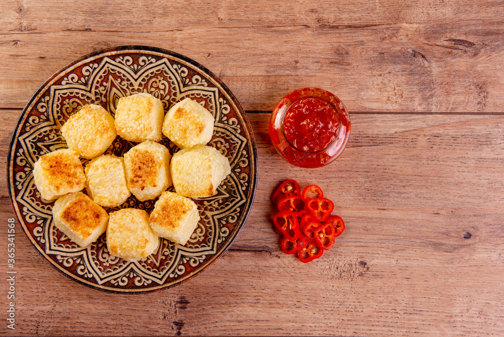 Tapioca dice served with pepper jelly. Wooden table Tapioca dice served with pepper jelly. Wooden table