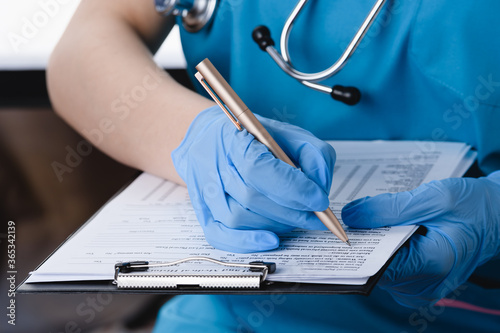 Medical girl fills out documents close up.