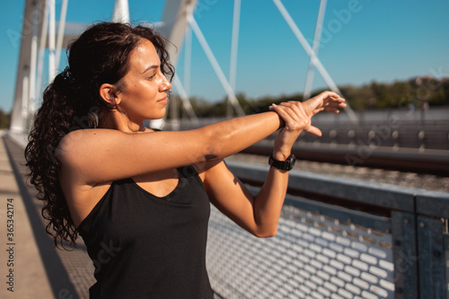 Young woman doing arm stretching exercise 