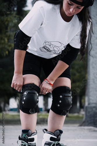 Joven mujer ajusta sus rodilleras antes de patinar