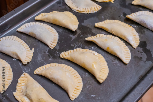 Delicious chiverre empanadas on a baking pan ready to go to the oven. Typical Hispanic holy week meal. photo