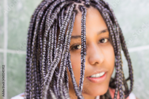 Selective focus on hair. Portrait of a young afro woman with box braids