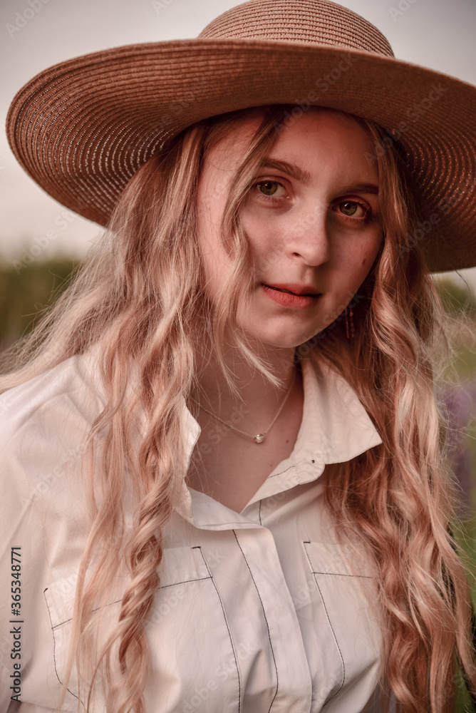 Large portrait of a charming blonde girl in a hat and white shirt . Large portrait of a charming blonde girl in a hat and white shirt .