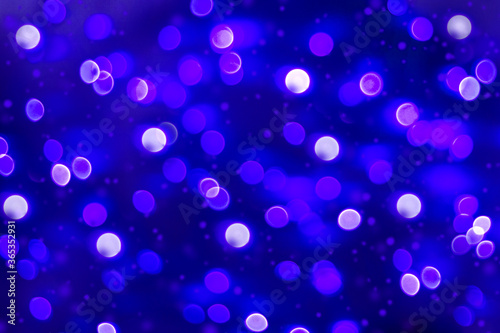 Festive Christmas sparkling defocused background. The blue lights of the holiday. Bright confetti glitter
