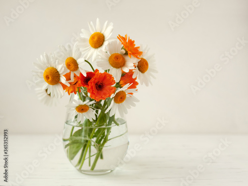 Wallpaper Mural Delicate chamomile flowers and yellow calendula on a light, wooden background on a Sunny day. Rustic style. Summer Torontodigital.ca