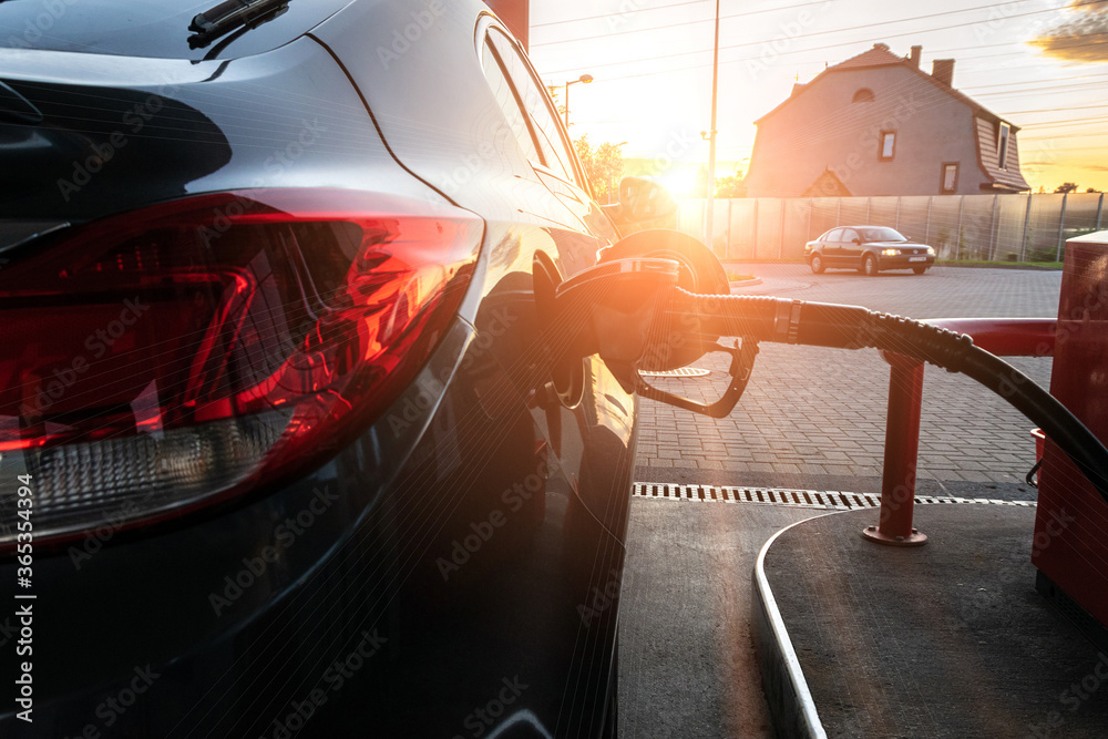 Naklejka premium Refueling car. Pump gas at petrol fuel station. Gasoline oil nozzle tank from hand person. Automotive industry or transportation concept.