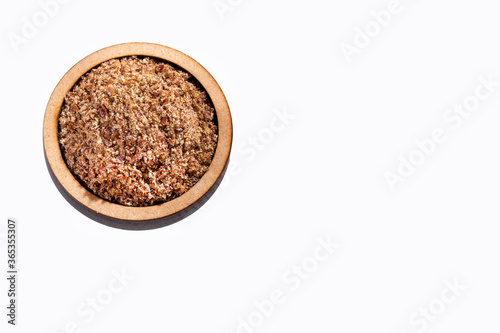 Crushed flax seeds in the wooden bowl - Linum usitatissimum