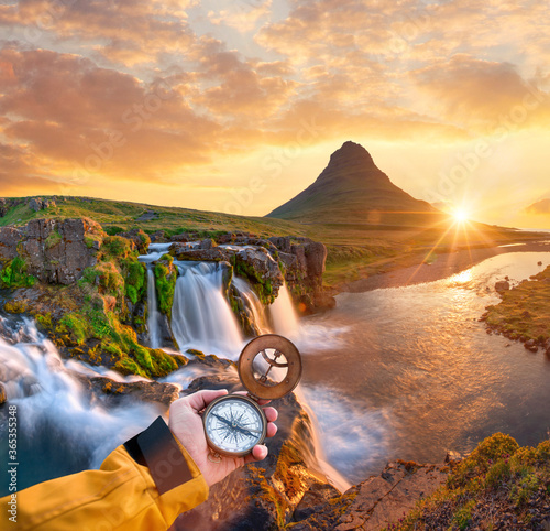 Beautiful landscape with old compass on traveler's hand. Traveling concept.