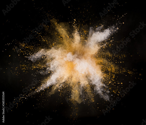 Colored powder explosion on black background. Freeze motion.