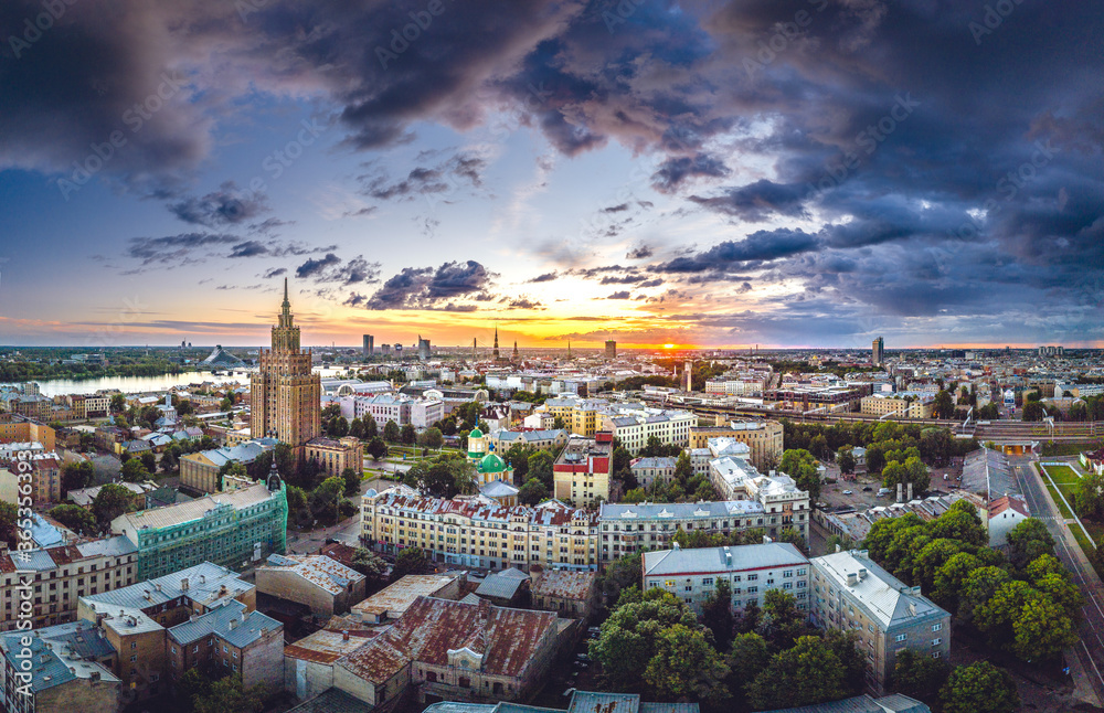 Aerial view of iconic Riga city in dramatic sunset. Modern architecture in Europe with storm clouds