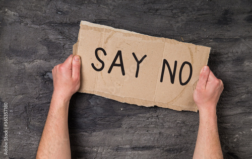 Young man holding say no cardboard in hands