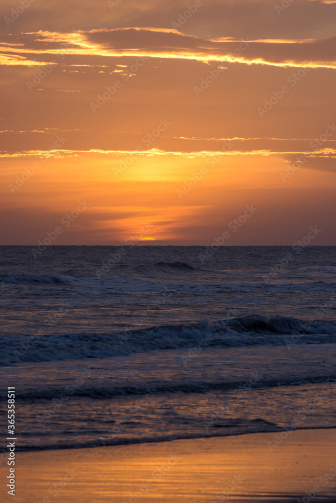 Sunset with rough sea on the beach