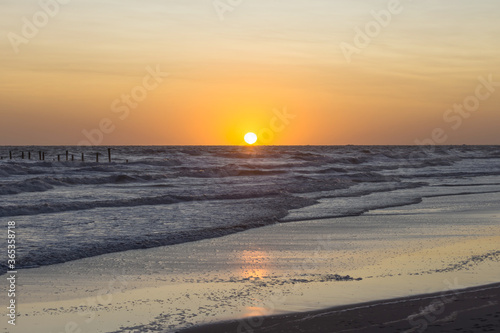 Sunset with rough sea on the beach