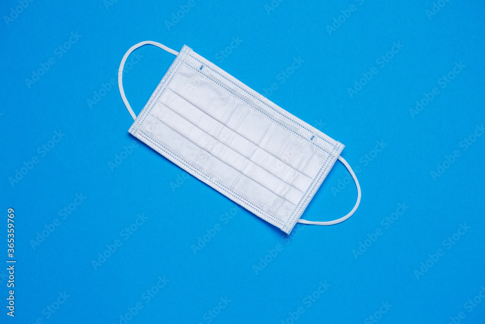 White medical surgical mask for protection against the virus on a colored background White medical surgical mask for protection against the virus on a colored background