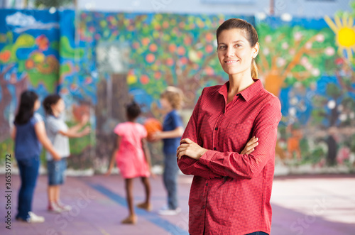 Elementary school scene. Teacher supervising playing children