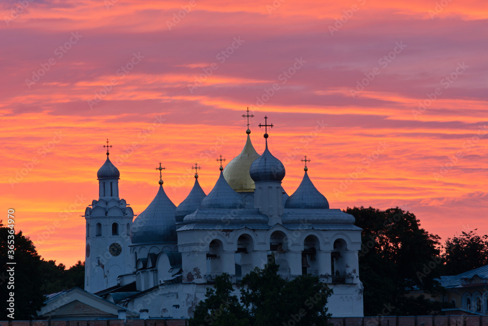 Veliky Novgorod. Russia. Novgorod Kremlin. Sunset. Domes of St. Sophia Cathedral, belfry and chapel against the background of a beautiful sunset sky