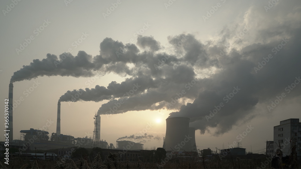 Exhaust from city industrial production at sunset, air pollution, toxic smog
