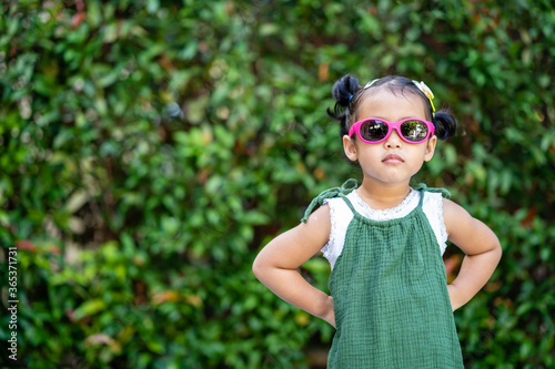 Cute little girl standing at garden in summer. © tienuskin