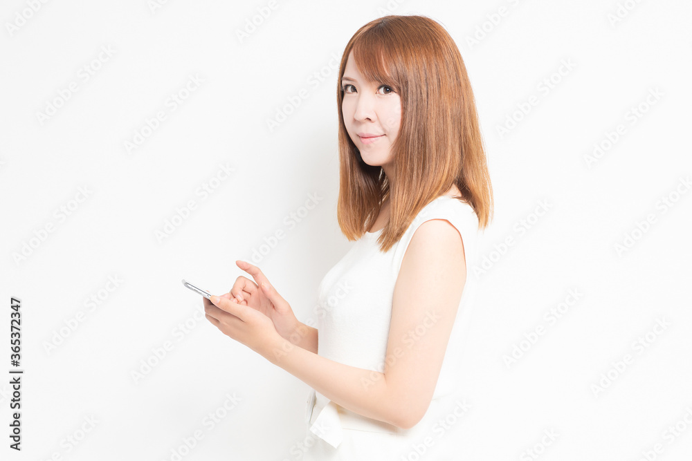 スマホを操作するワンピースを着た女性 スマホを操作するワンピースを着た女性