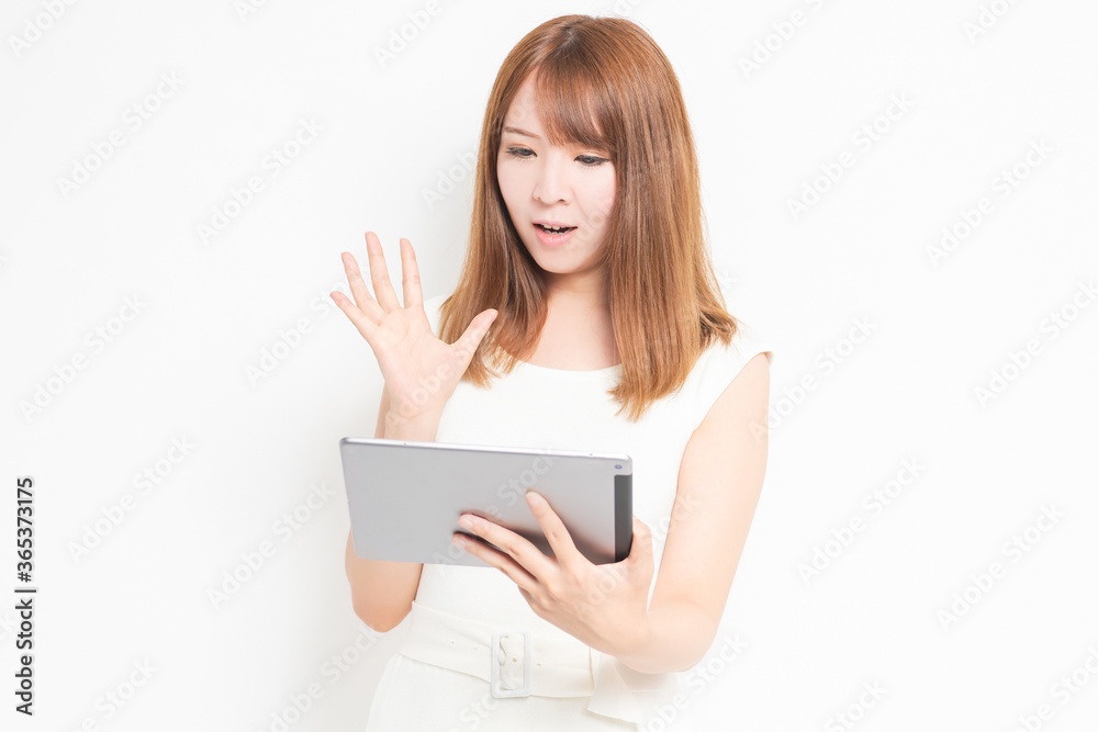 タブレット端末を使うワンピースを着た女性