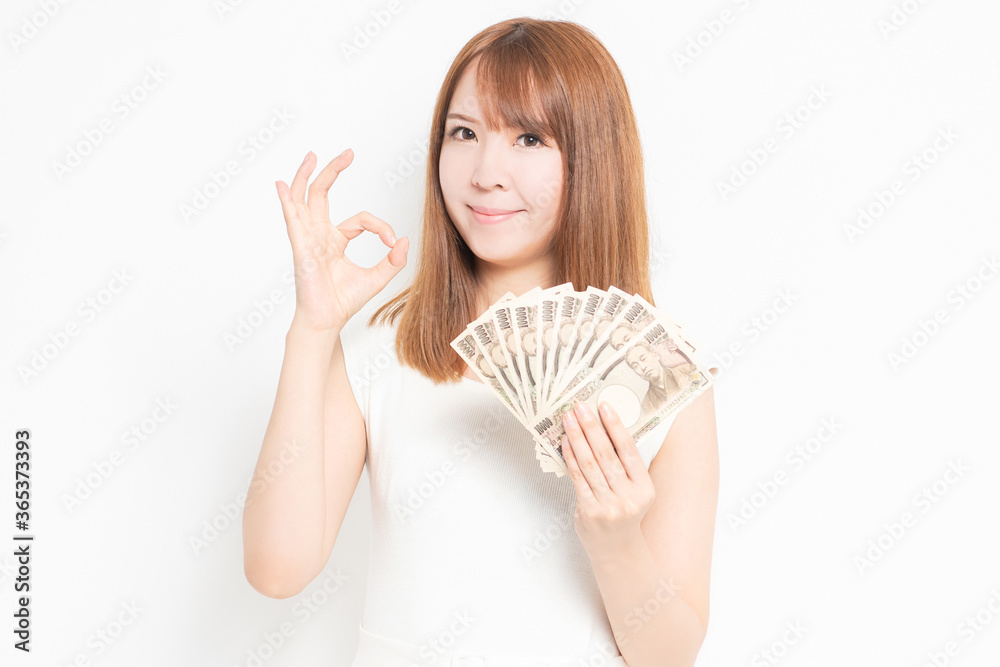お金を手に持つワンピースを着た女性