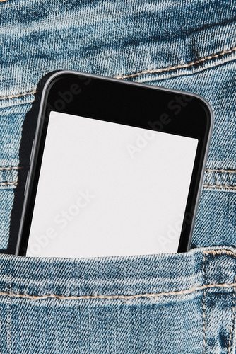 Mobile phone with blank mockup screen in the pocket of blue jeans