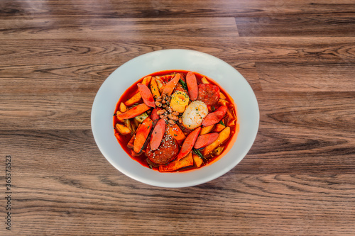 Obraz na płótnie Korean Budae Tteokbokki at a 45 degree angle on a wood table in a white bowl. w salonie