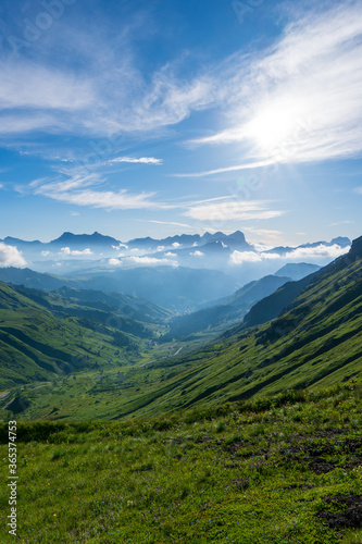 Summer morning in Dolomite Alps. Beautiful sunny landscape in the mountains. Ski hills of Piz Boe mountain in morning mist. View from Sella pass  Province of Trento  Italy  Europe.