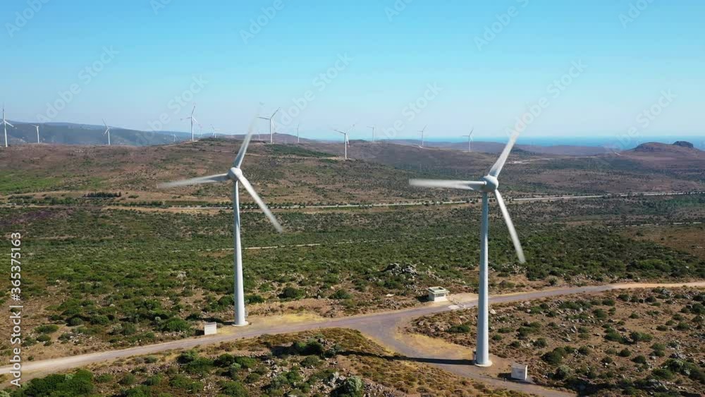 Wind Turbines Spinning. This stock video features turbines in a wind farm from an aerial perspective. Wind Turbines Spinning. This stock video features turbines in a wind farm from an aerial perspective.