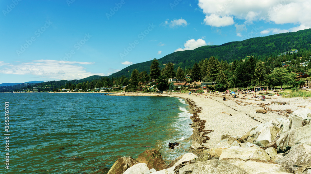 Popular BC urban beach park with mountains in background - summer
