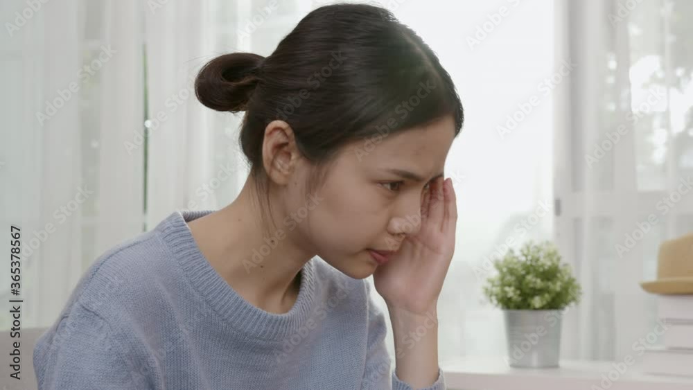 Tired young Asian woman sitting and have a headache because migraine. Tired young Asian woman sitting and have a headache because migraine.