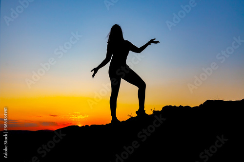 Silhouette of carefree woman at sunset