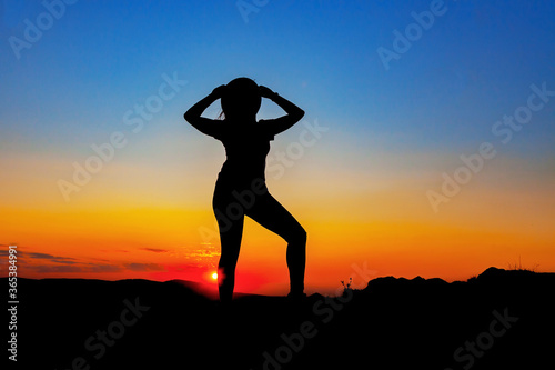 Silhouette of a woman in a hat at sunset