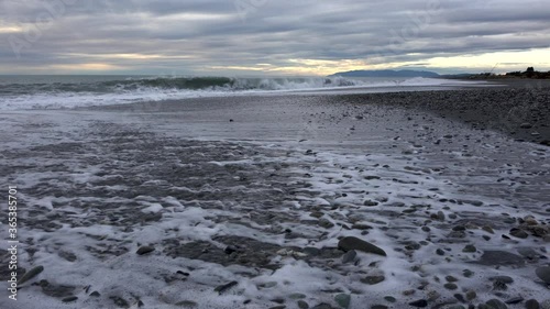 Hokitika at sunset with waves lapping across the pebbled beach
