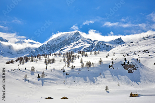 View of snow mountain and a small house along Bernina Express train near Ospizio Bernina