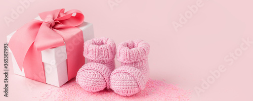 Close up of baby shoes, present gift box - sweetness and baby booties on pink background, first newborn party background, birthday, gift present giving concept, celebrate card
