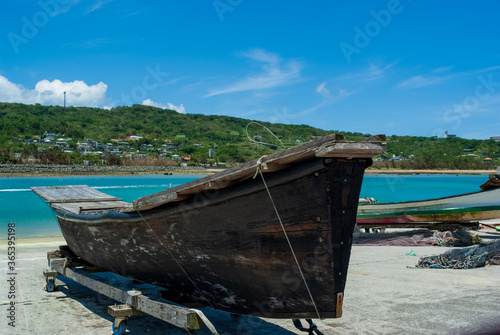 夏の青空と観光地の奥武島の漁港に並ぶ伝統的な船のサバニ