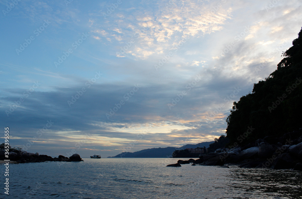 View of dawn at the seaside with the dramatic sky, boat and mountain, Tioman Island