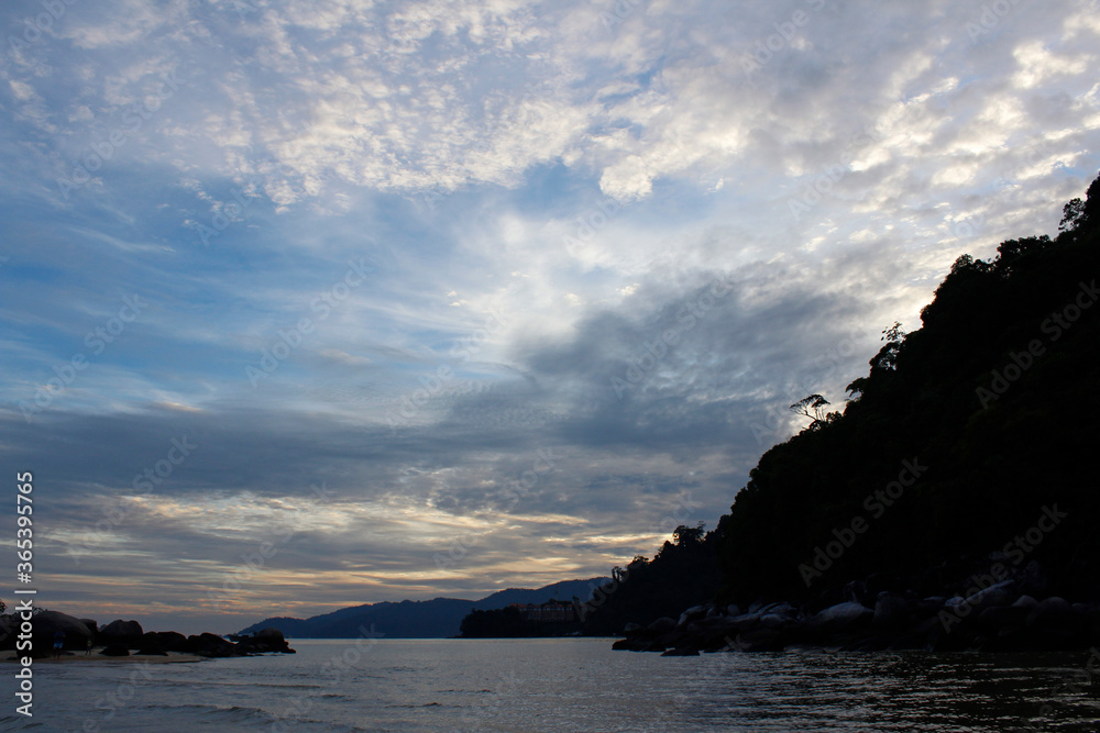 View of dawn at the seaside with the dramatic sky, boat and mountain, Tioman Island
