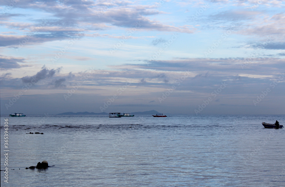 View of dawn at the seaside with a man on the boat, Tioman Island