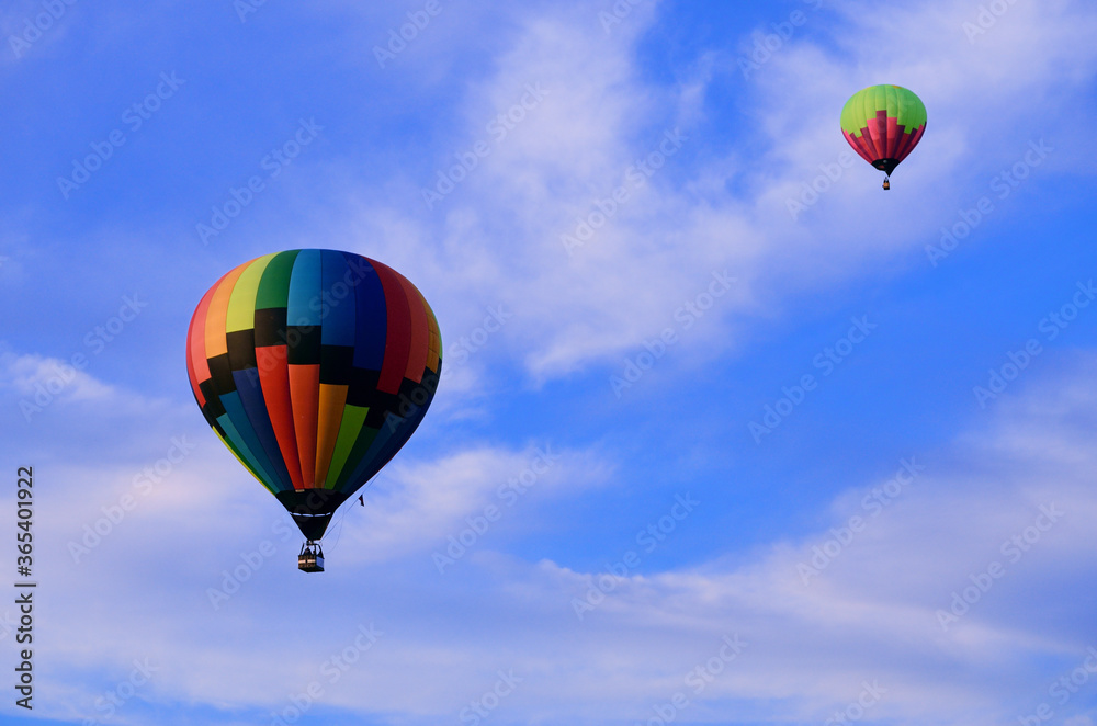 Obraz premium Two multicolored balloons in rise high into the sky